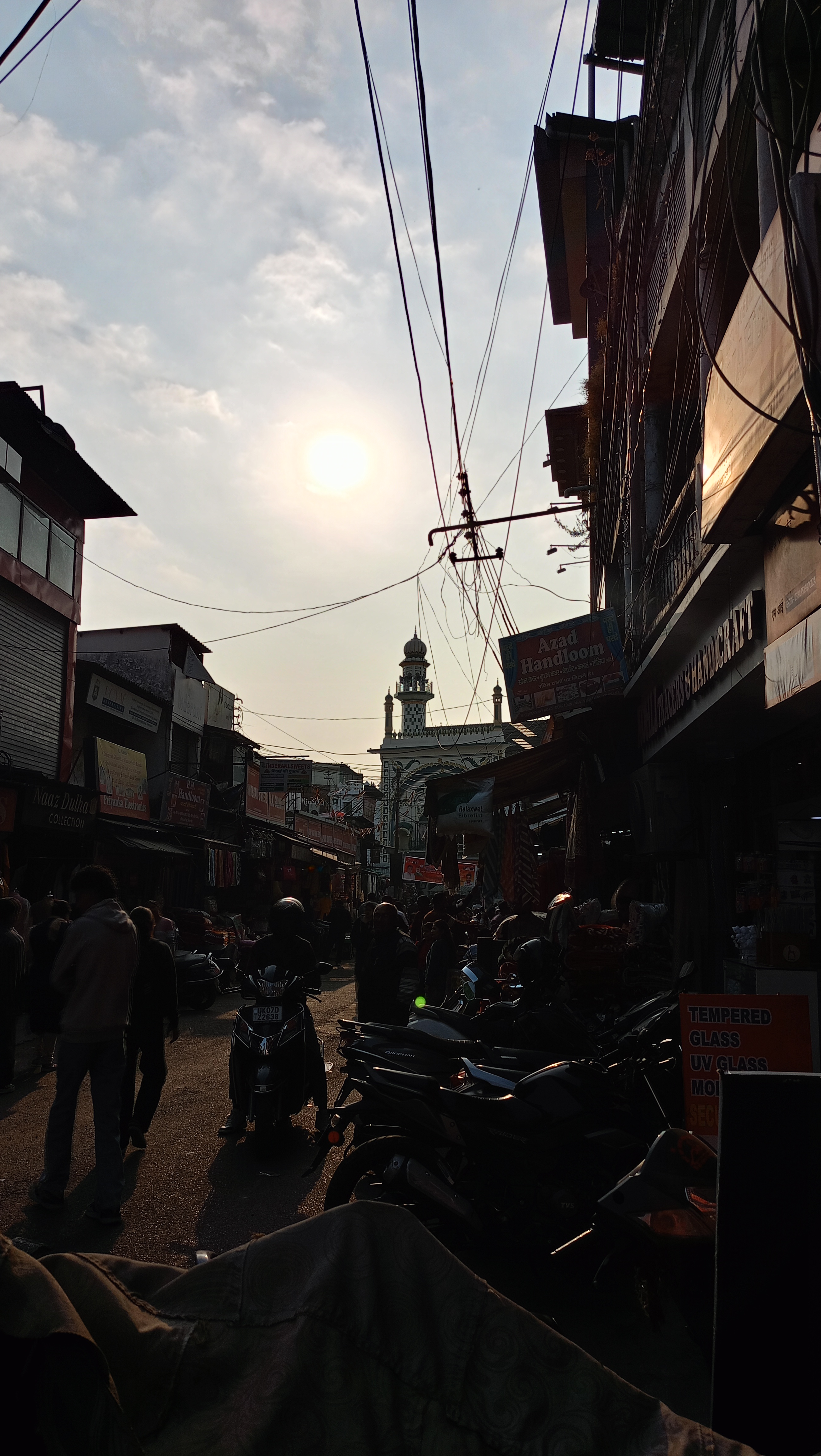 Narrow street framed by evening light and overhead wires