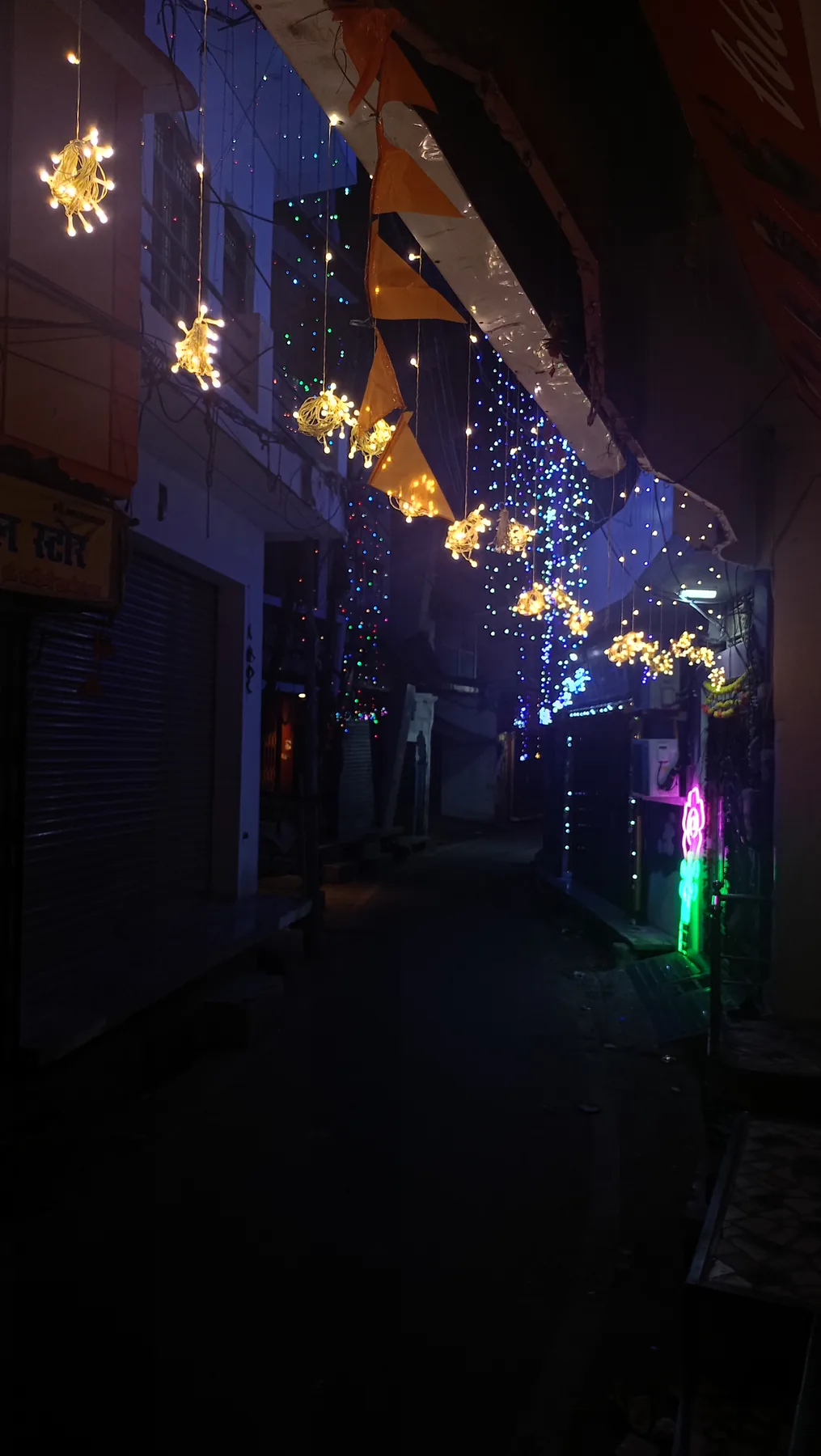 Narrow street decorated with lights at night