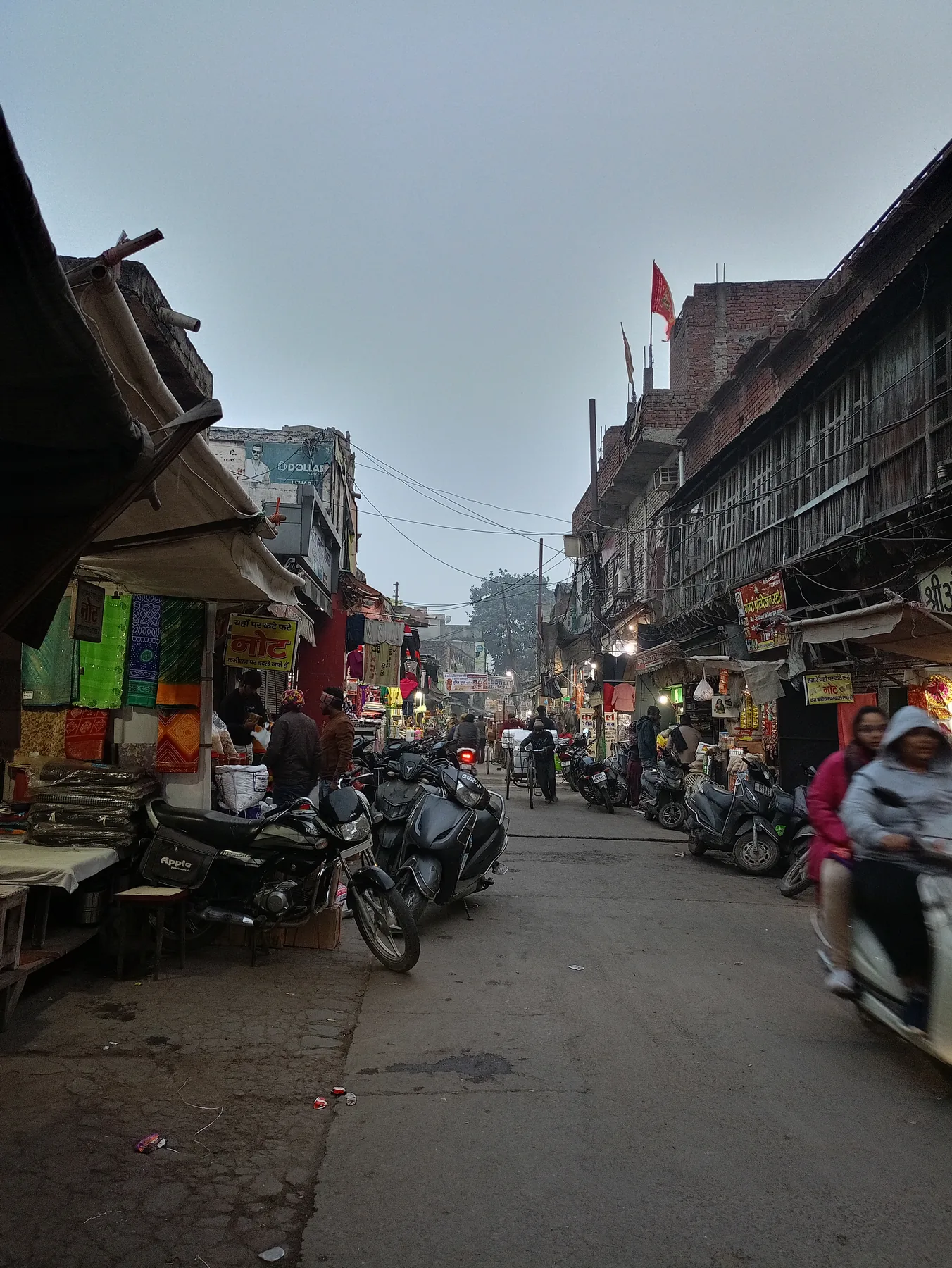 Busy market lane with people and buildings